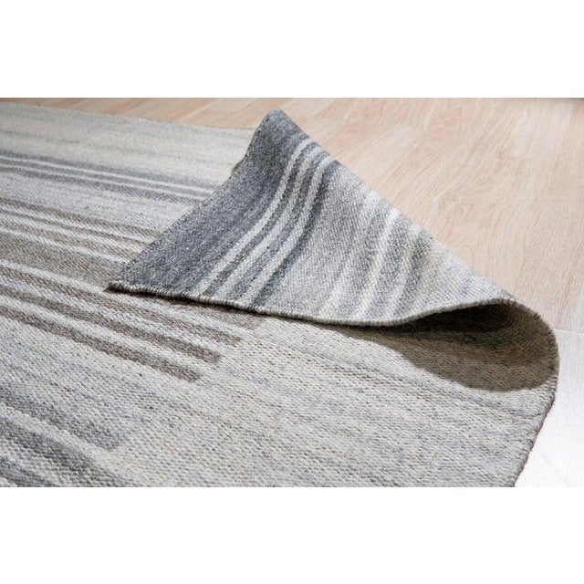 This hand woven gray rug is crafted from a blend of wool and viscose materials. Originating from India, this piece...