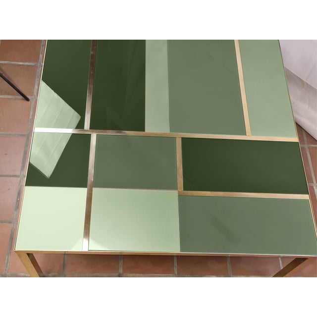 This square coffee table features green Murano glass of different shades and elegant brass bands, embodying the Mid-...