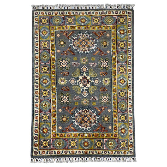 A slate gray field sets off three stylized floral medallions in cream, blue, rust, and burgundy. Smaller flowers fill the...