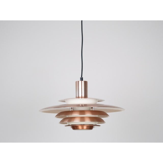 The lamp's form was designed based on the principle of a reflective system that directs light not only downward but also...