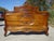 A very old, handcrafted bed, dating from the late 19th or early 20th century, made of solid walnut, with rounded curves...