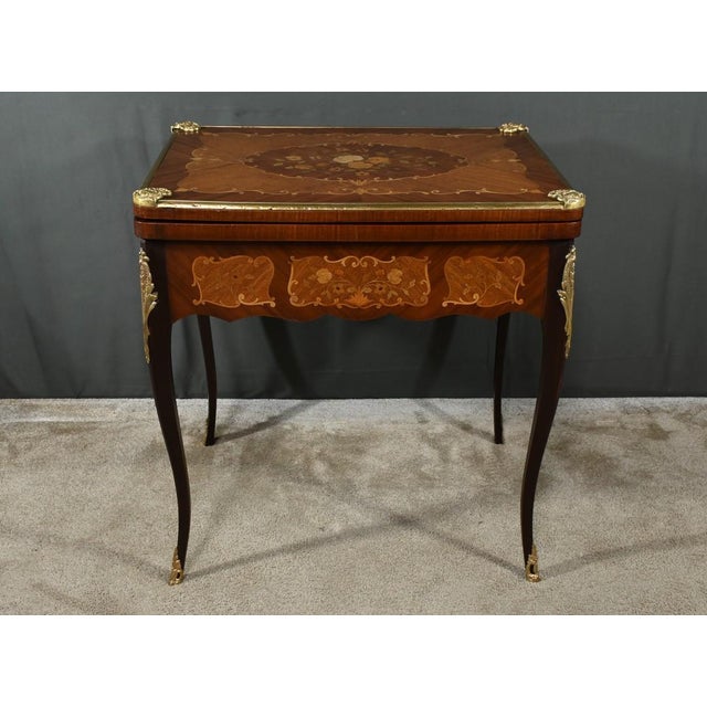 This Louis XV/Louis XVI transition style mahogany games table is a true masterpiece of cabinetmaking. Its top,...
