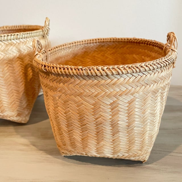 2 Vintage Stacking Baskets made of texture woven bamboo with indents for bottom feet both have 2 small handles. The woven...