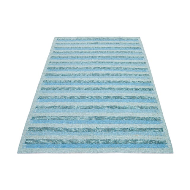 This flatweave rug features a chic contemporary Swedish design with a green field color. It has a striped pattern...