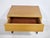 Small wooden sideboard with drawers, reminiscent of the 1960s mid-century modern design. Its clean, compact form is...