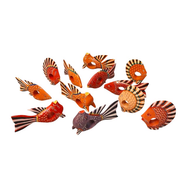 A set of twelve wooden napkin rings carved in the shape of tropical fish. Hand painted in vibrant orange, red, yellow,...