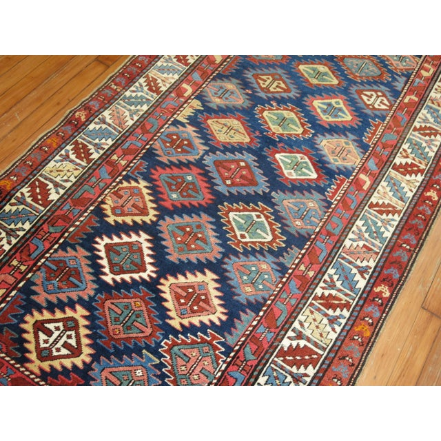 A geometric tribal looking Caucasian Shirvan rug from the early 20th century. Colorful geometric design on a navy blue...
