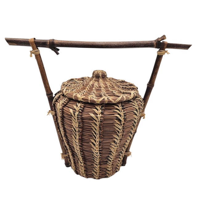 A vessel spun from pine and patience, held aloft in a frame of raw branch. This handwoven piece by Jennifer Kelly for...