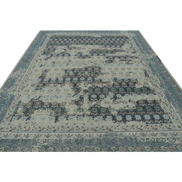 Hand-knotted in wool, this 9x12 rug in blue and teal tones and floral patterns, features a hint of inspiration from...