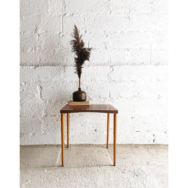This delicate side table dates back to the 1960s and was crafted in the typical minimalist style of the mid-century era....