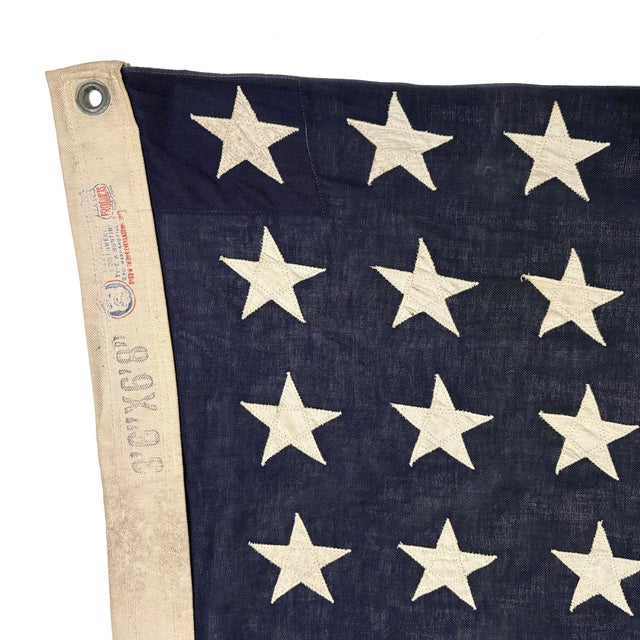 This vintage American flag is made from a cotton cloth with fully sewn stars and stripes. Please note staining and other...