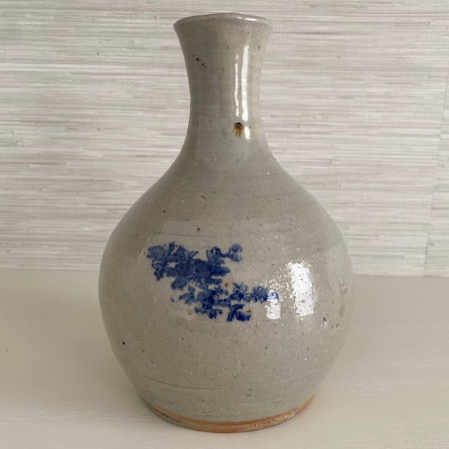Antique ceramic bottle vase with cobalt blue blossom vine motif on opposite sides. Rustic charm originally made for...