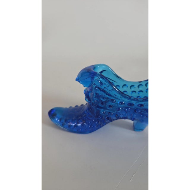 This beautiful figurine is a Vintage Fenton Art Glass Hobnail Cat Head Slipper in the lovely Colonial Blue color. The...
