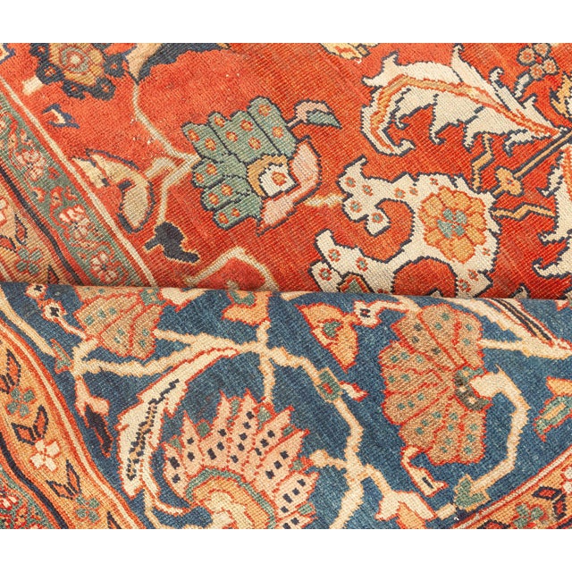 An early 20th century Persian Sultanabad rug, the rust red field with an overall pattern of geometric flowerheads,...