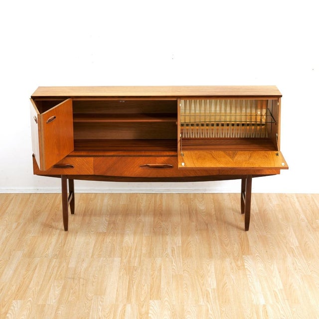 Exceptional mid century English teak sideboard or drinks cabinet attributed to Avalon Furniture. Crafted in the Anglo-...