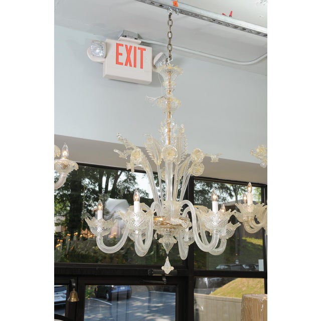 This particular piece is a richly detailed Murano chandelier intertwined with handblown blossoms and foliate motifs. The...