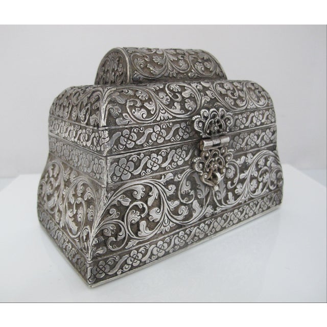 Traditional antique South Asian lidded chest box. Embossed silver metal alloy showing an intricate scrolling flower...