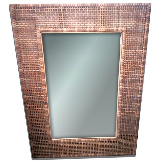 This handcrafted cane-framed wall mirror is a sculptural nod to the intersection of natural form and refined function....