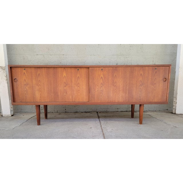 Hans Wegner RY-26 teak Danish Modern credenza with sliding doors and fitted interior. Features 6 interior shelves, 5 being...