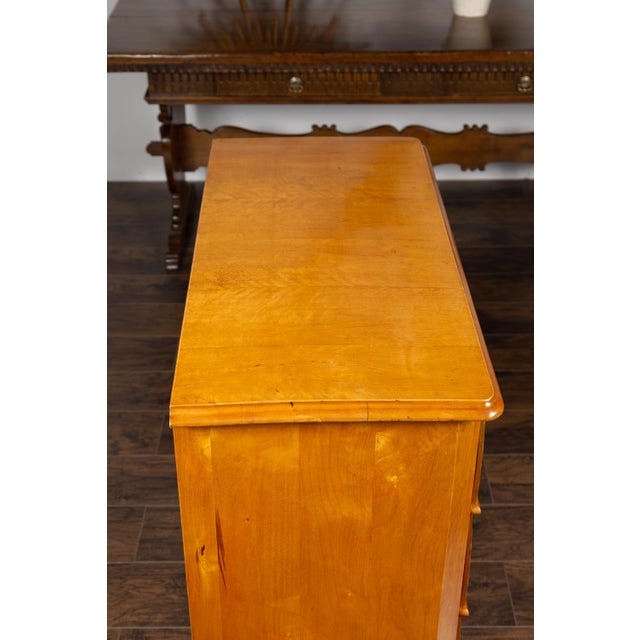 An Austrian Biedermeier style four-drawer commode from the late 19th century, with birch veneer and shield-shaped...