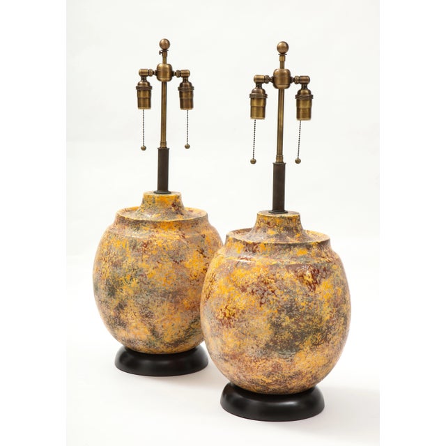 Wonderful pair of 1960's large Italian ceramic lamps. The vessel shaped lamps have a textured "Scavo" glazed finish and...