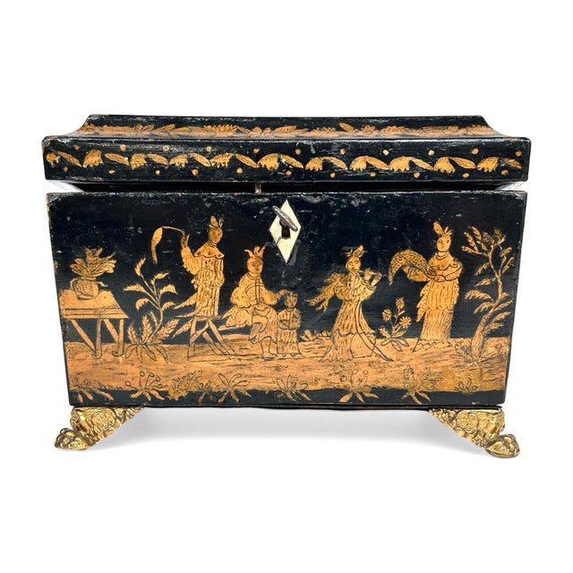 English Regency Chinoiserie Black Lacquer and Gilt Tea Caddy. This tea caddy features romanticized Eastern landscapes with...