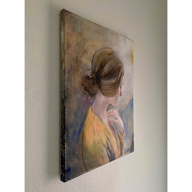 This oil on linen painting captures a contemplative figure draped in a soft yellow garment, her gaze directed downward and...
