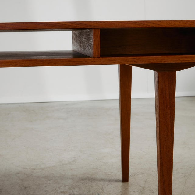 Designed with both aesthetics and practicality in mind, this 1950s Danish coffee table offers more than meets the eye. The...