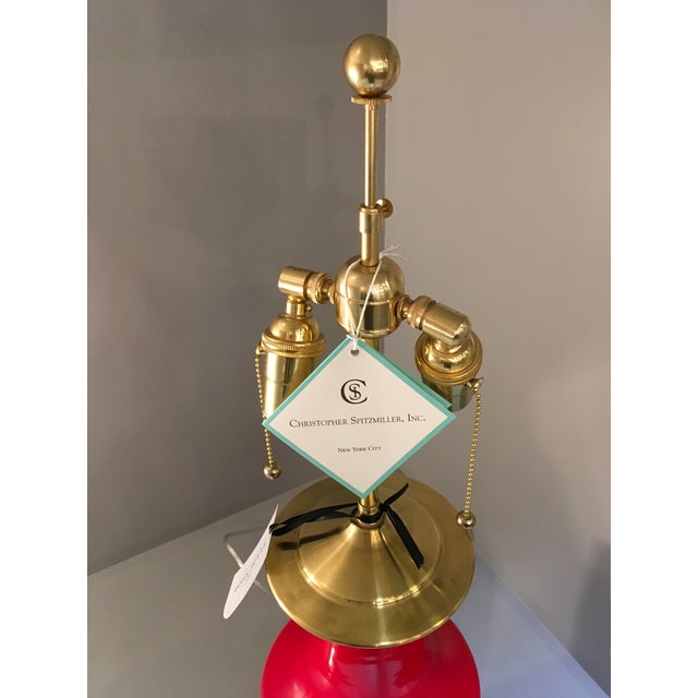 Christopher Spitzmiller lamp in red with a 23k gold water gilt base and double socket. The lamp neck can be adjusted for a...