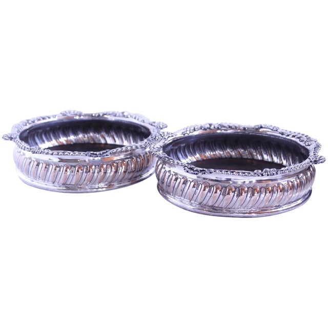 An elegant pair of wine coasters with decorative serpentine shell and acanthus relief elements binding the rims. These are...