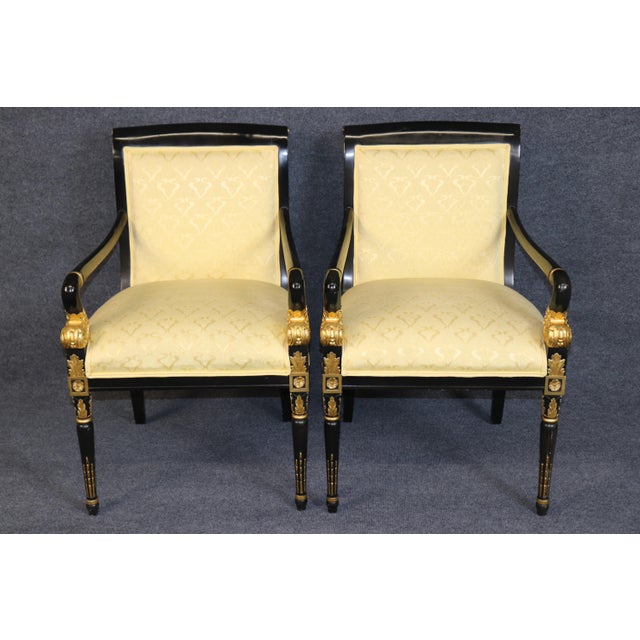 This impressive suite of twelve ebonized and parcel-gilt dining chairs, comprising ten side chairs and two armchairs, is a...