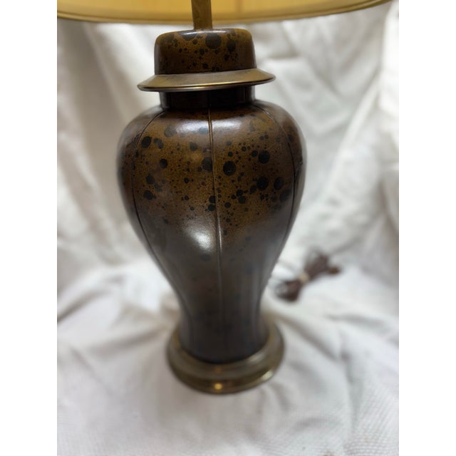 Unique vintage ginger jar lamp that is wrapped in a faux cowhide leather. Shade is marked with F. Cooper shade. Lamp is...