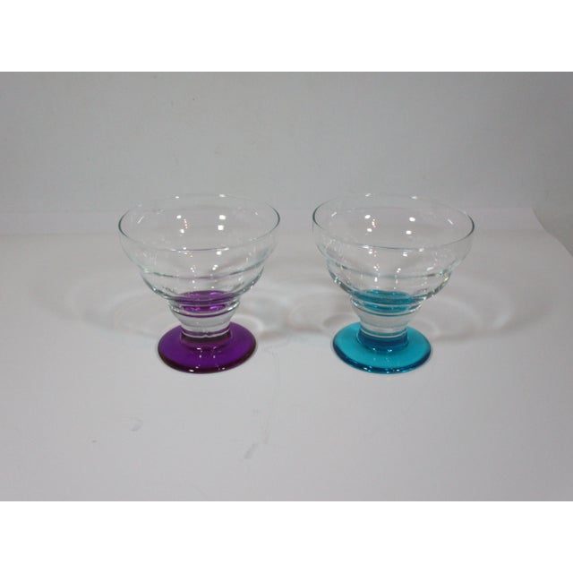 Set of four mid-century glass coupe's that are hand blown and have clear graduated tiers on a purple or peacock blue...
