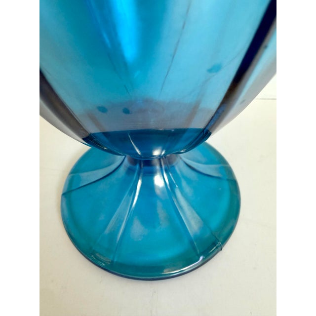 This whimsical lidded pedestal candy dish/jar is crafted in luminous iridescent peacock blue glass, displaying shifting...