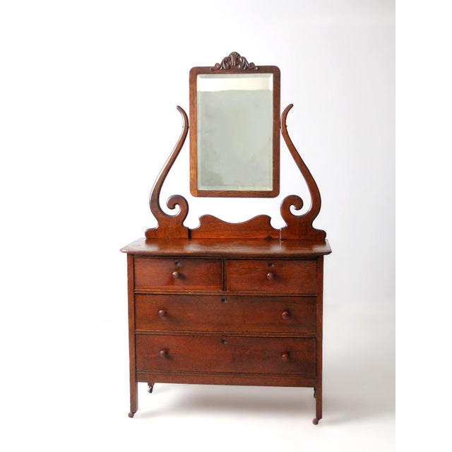 This antique Victorian era dresser features a tall beveled glass mirror and a well-balanced, architectural silhouette that...