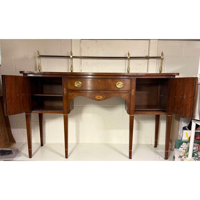 Lovely serpantine sideboard by Statton featuring inlaid medallion design, spacers on legs and a gallery rail. This classic...
