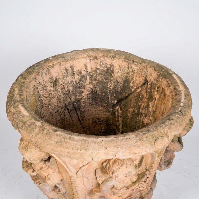 A substantial garden basin in reconstituted stone with a terracotta patina, adorned with a rich decoration of sculpted...