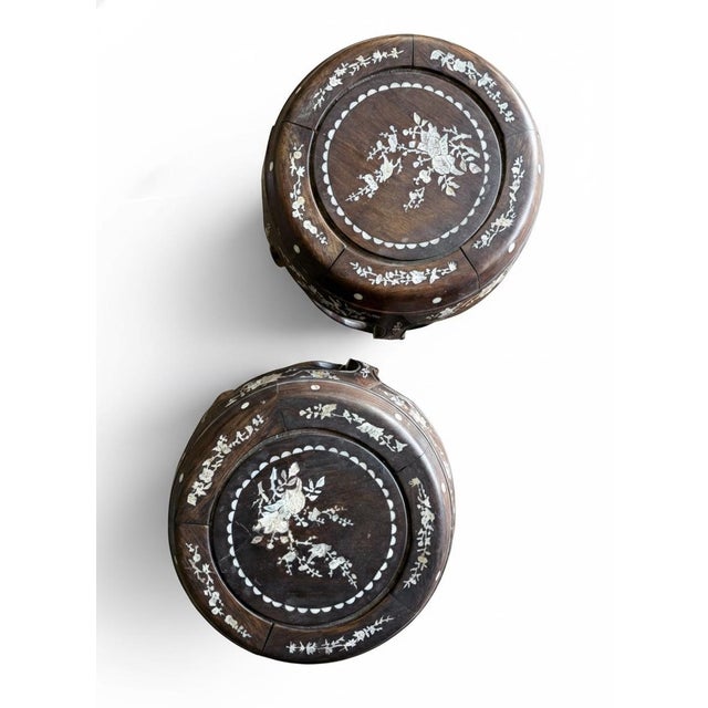Beautiful pair of vintage Chinese round hardwood stools featuring intricate mother-of-pearl style floral inlay throughout....
