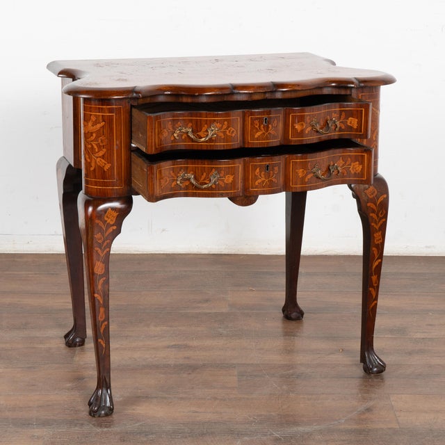 Elegant Dutch marquetry inlaid oak side table with two serpentine drawers resting on long inlaid cabriolet legs. Please...