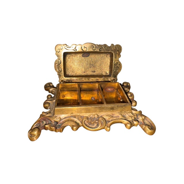 This stunning 19th century stamp box, cast in bronze, features an ornate and unusual portrait of a cherub riding a winged...