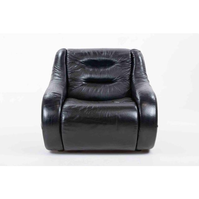 A generously proportioned lounge armchair featuring an enveloping, organically contoured silhouette characteristic of...