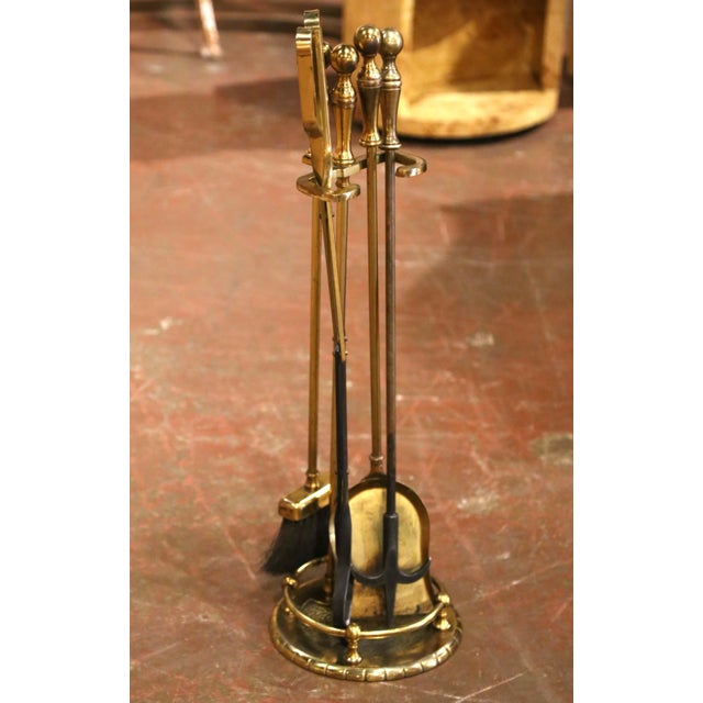 Elegant in its restrained neoclassical styling, this vintage fireplace tool set combines polished brass with blackened...