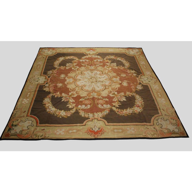 Handwoven in wool, this 12x12 antique oversized French Aubusson rug, dating to circa 1800, is a refined example of the...