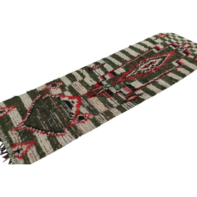 Hand-knotted in fabric circa 1950-1960, this vintage 3x9 Moroccan runner and Boucherouite rug is believed to hail from the...