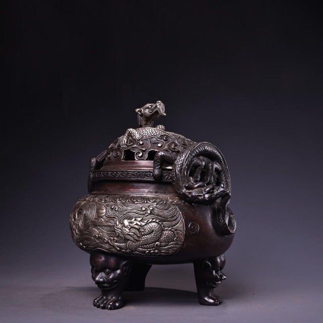 A commanding Chinese lidded censer cast in patinated bronze, finished with silver-washed high-relief chasing across the...