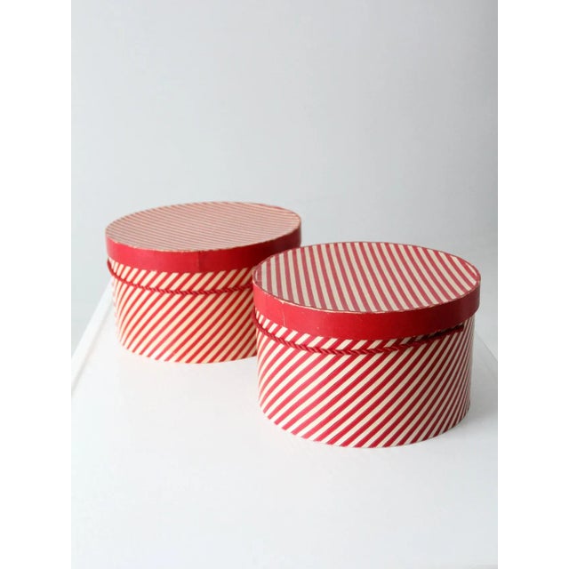 This is a pair of vintage hat boxes. Red and white "candy cane" striped paper colors the round hat boxes. They have red...