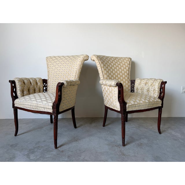 Beautiful pair of vintage Regency Revival armchairs featuring elegant carved wood frames, tall flared backs and cream...