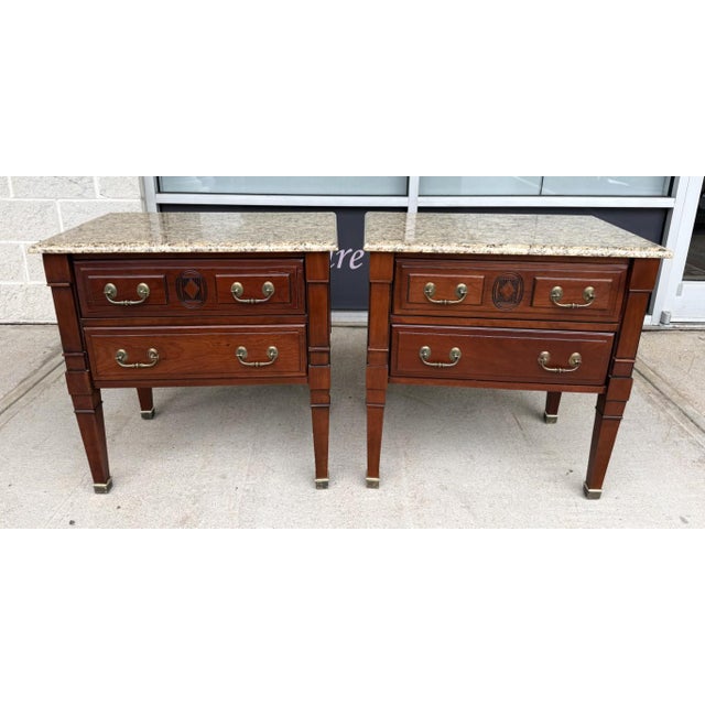This handsome pair of Harden nightstands features warm mahogany finishes, classical brass hardware, and geometric carved...