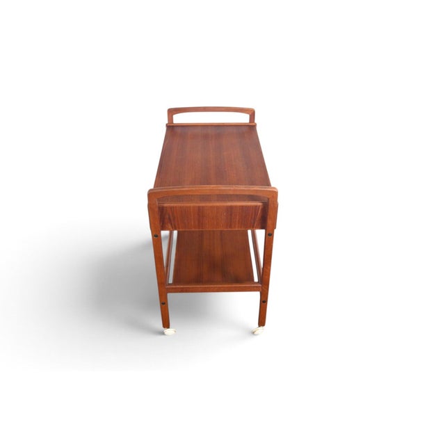 This two-drawer bar cart was made in Denmark during the 1960s. The teak cart offers two drawers of storage alongside its...