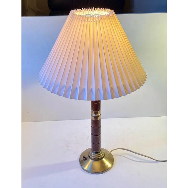 A large stylish Swedish Table Light composed of af white fluted shade, a architecturally stained brass base and a stem set...